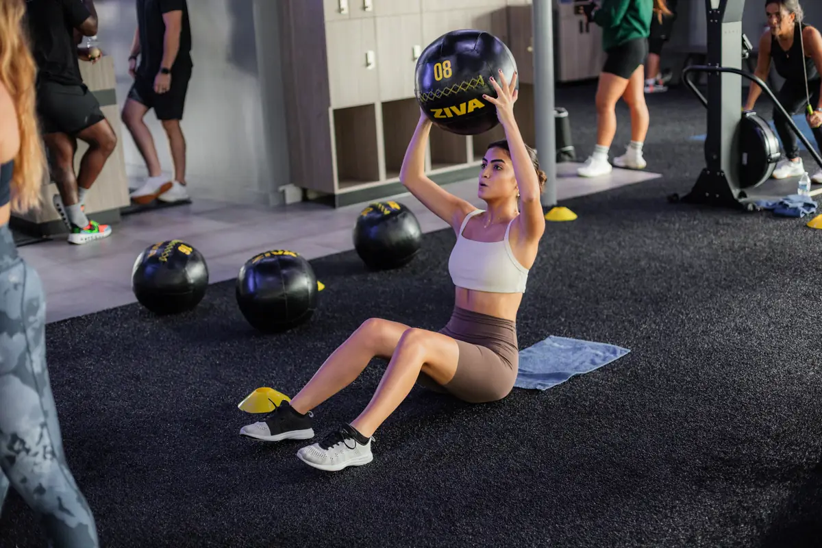 Woman doing a medicine ball sit-up during a core workout