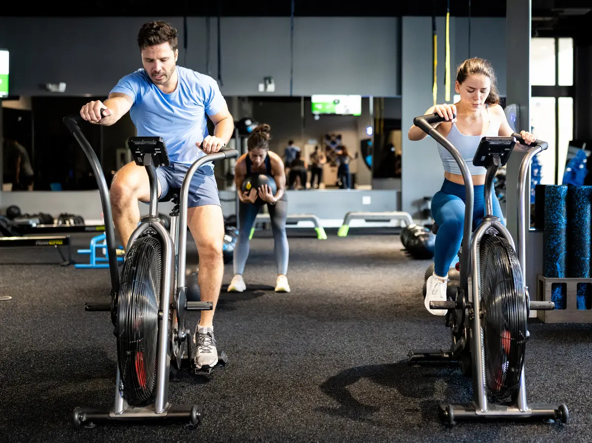 SWEAT440 members riding air bikes during a conditioning station