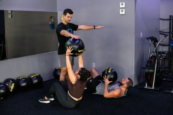 coach and members working out gym class SWEAT440