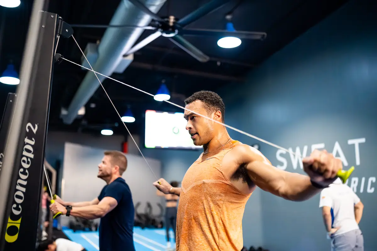 Man performing an exercise on a cable machine at SWEAT440