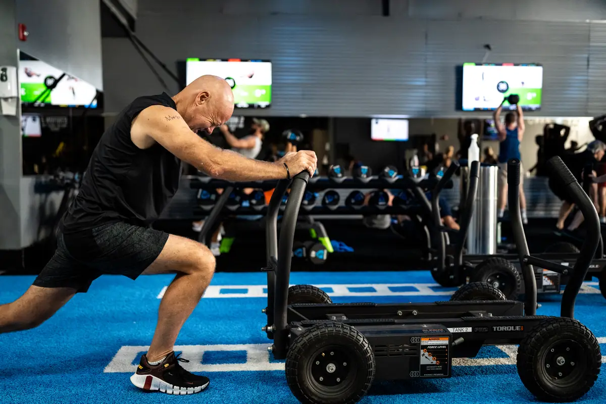 Man pushing a weighted sled at SWEAT440