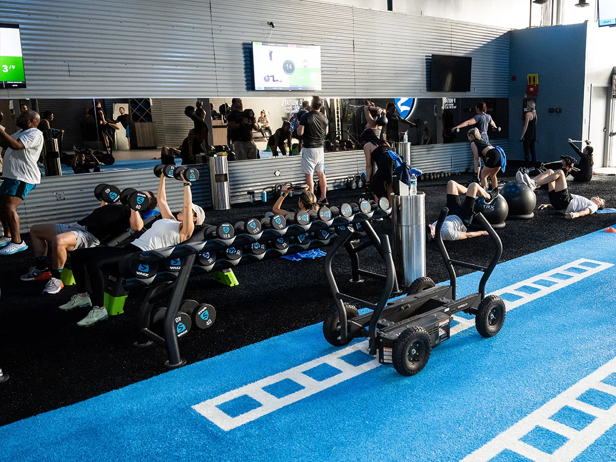 SWEAT440 studio floor set up with dumbbells, agility ladder and sled for a time-efficient workout