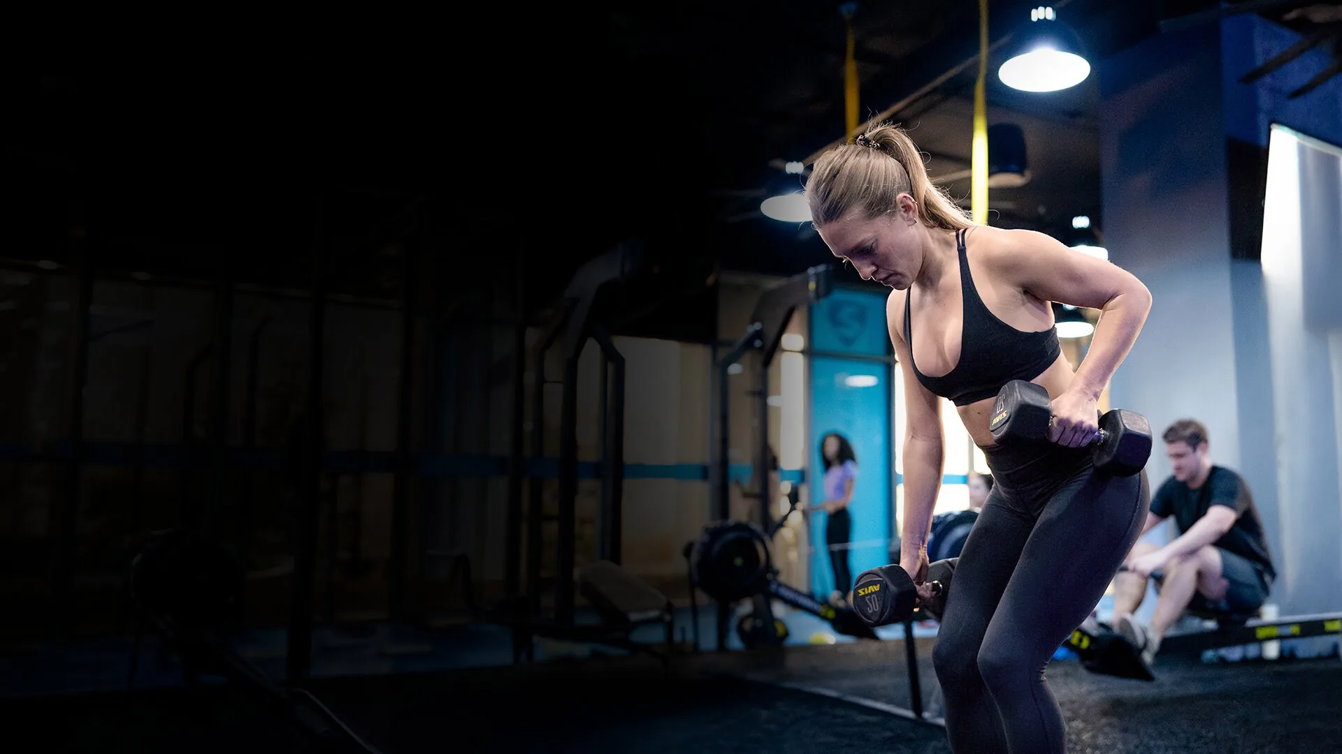 SWEAT440 member doing a dumbbell row strength exercise