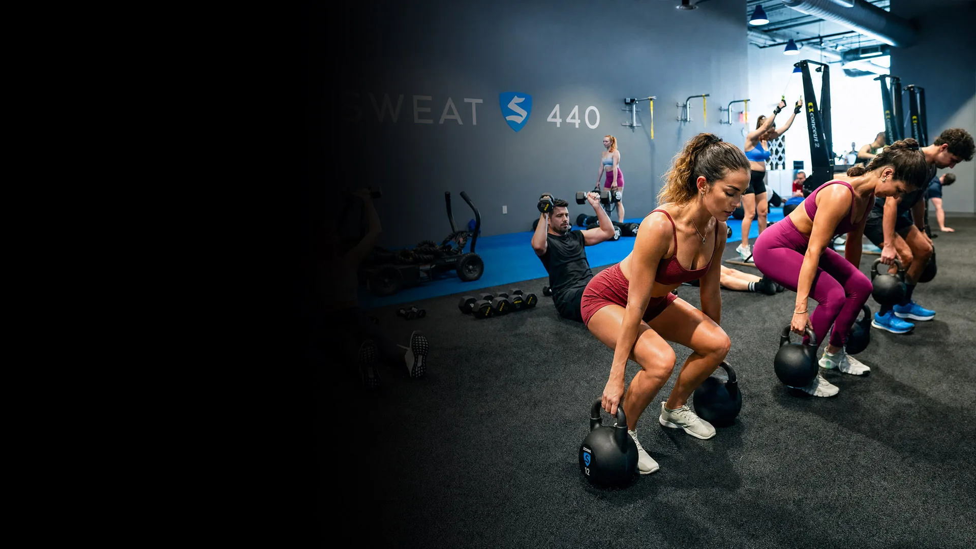 SWEAT440 members doing kettlebell squats in a group class
