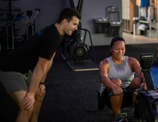 coach helping member gym class SWEAT440