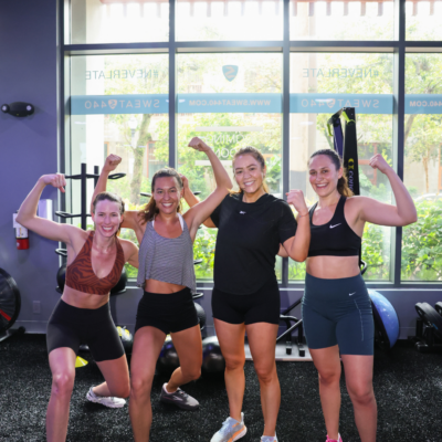 Group of women feeling stronger and flexing after working out at SWEAT440