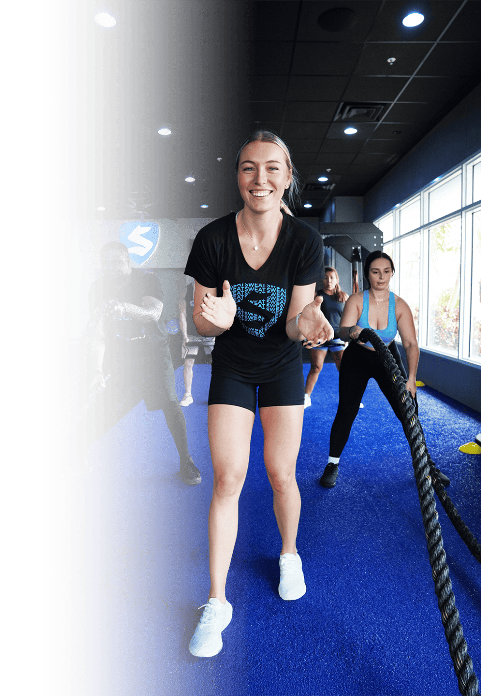 SWEAT440 coach and member two women working out gym class